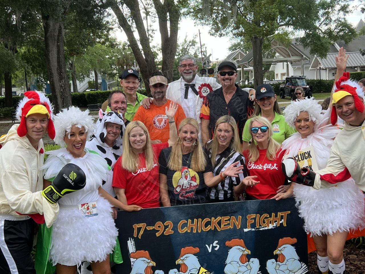 Group photo of people dress in chicken gear holding up a sign that says "17-92 Chicken Fight" 