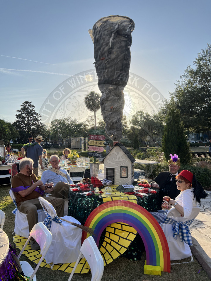 a table decorated like the movie The Wizard of Oz. There is a table with a homemade tornado on top of the house.