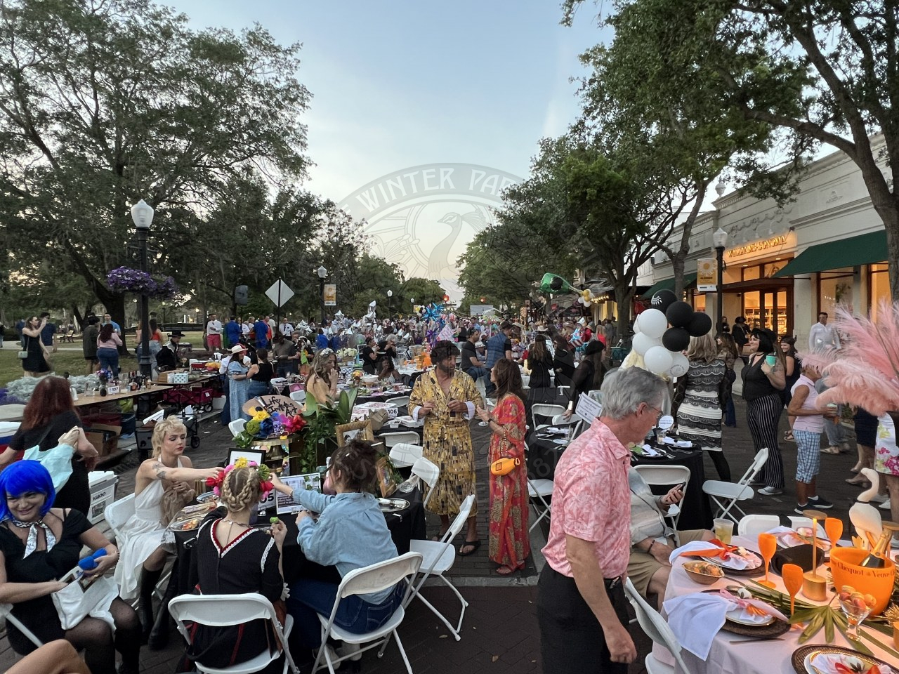 Overview of dinner on the avenue event. Park Avenue is filled with tables and a lot of people standing in between tables and sitting at tables.