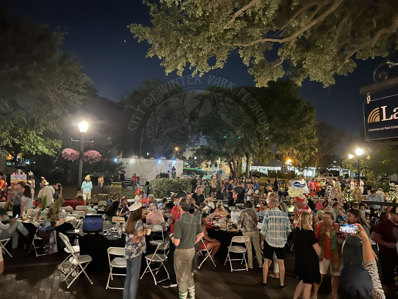 Overview of dinner on the avenue event. Park Avenue is filled with tables and a lot of people standing in between tables and sitting at tables.