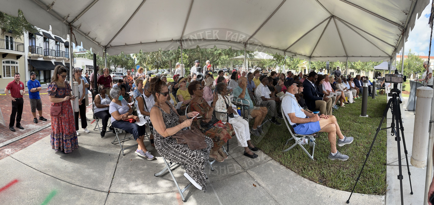 people sitting in rows of seats underneath a tent waiting for the speaker to start talking,