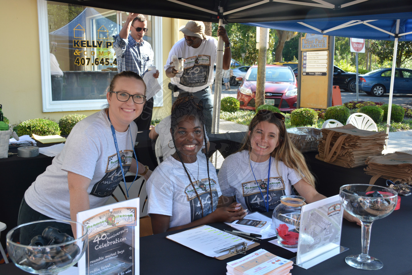 Three female city Parks and Recreation staff members at welcome table with warm smiles