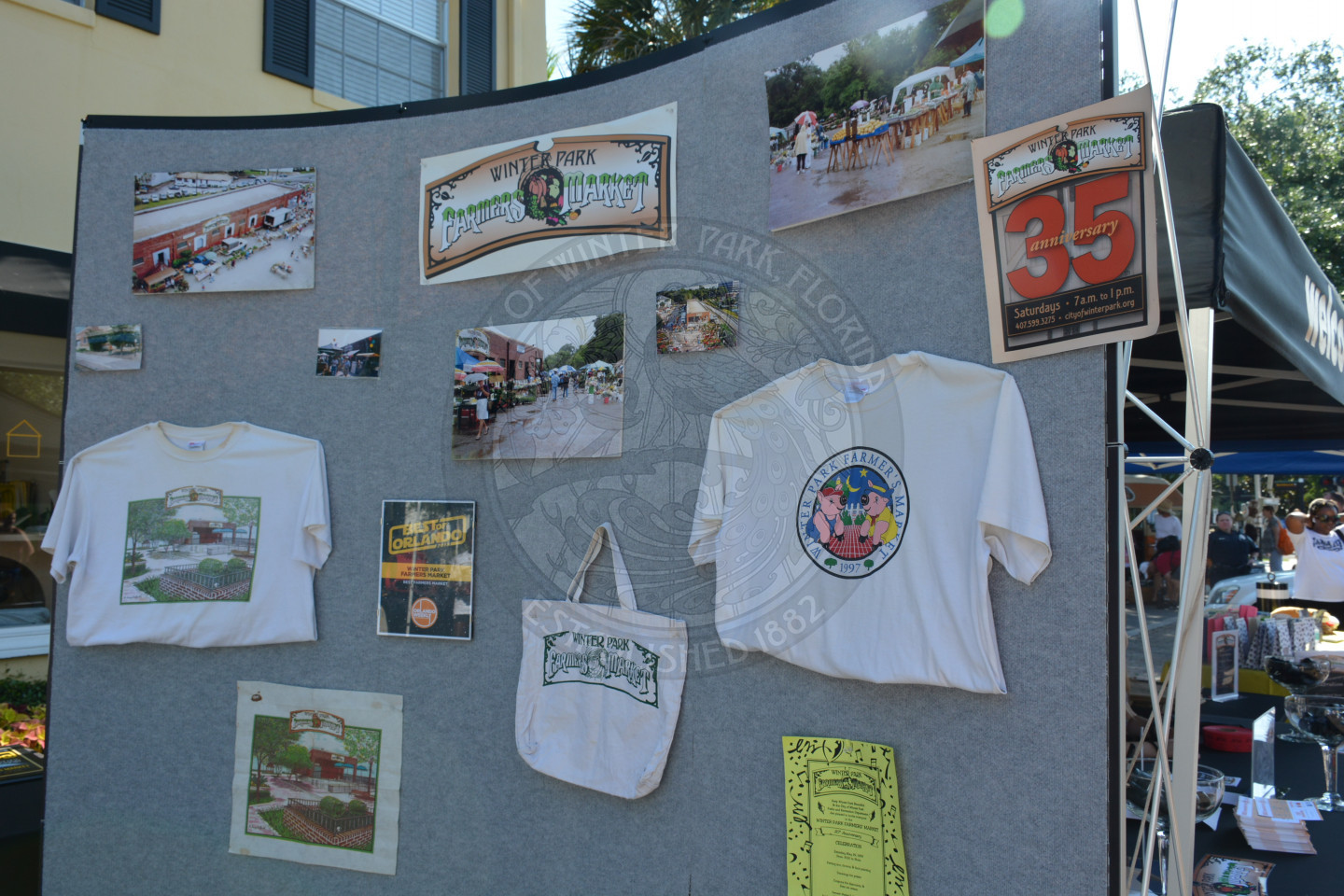 Display of Farmers" Market memorabilia including t-shirts, photos, logos and bags