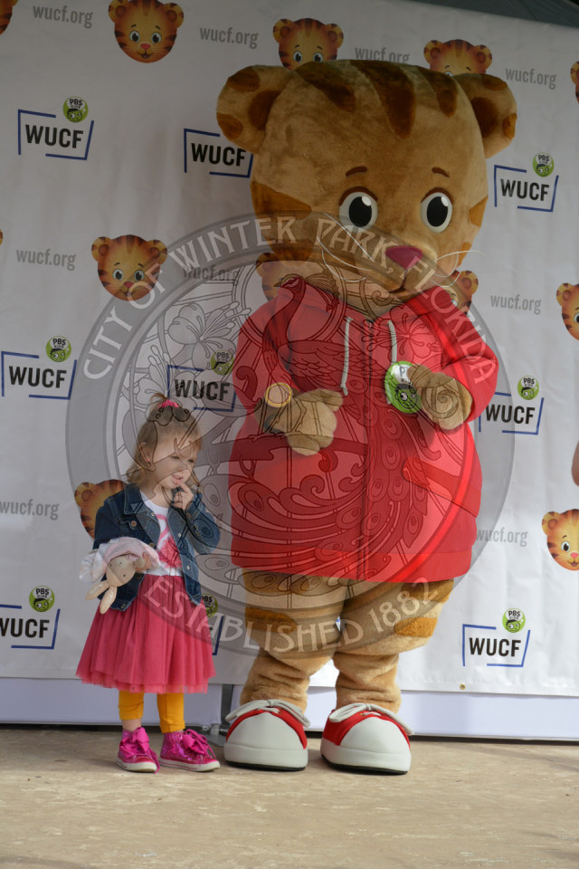 Little girl standing next to Daniel Tiger character