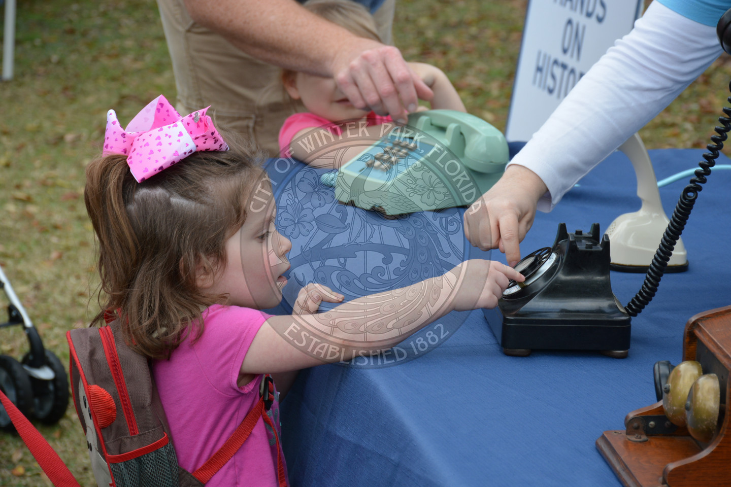 Little girl reaching for old fashioned phone to dial a number