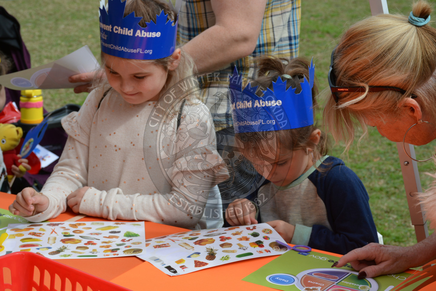 Children playing with stickers at arts &amp; crafts table