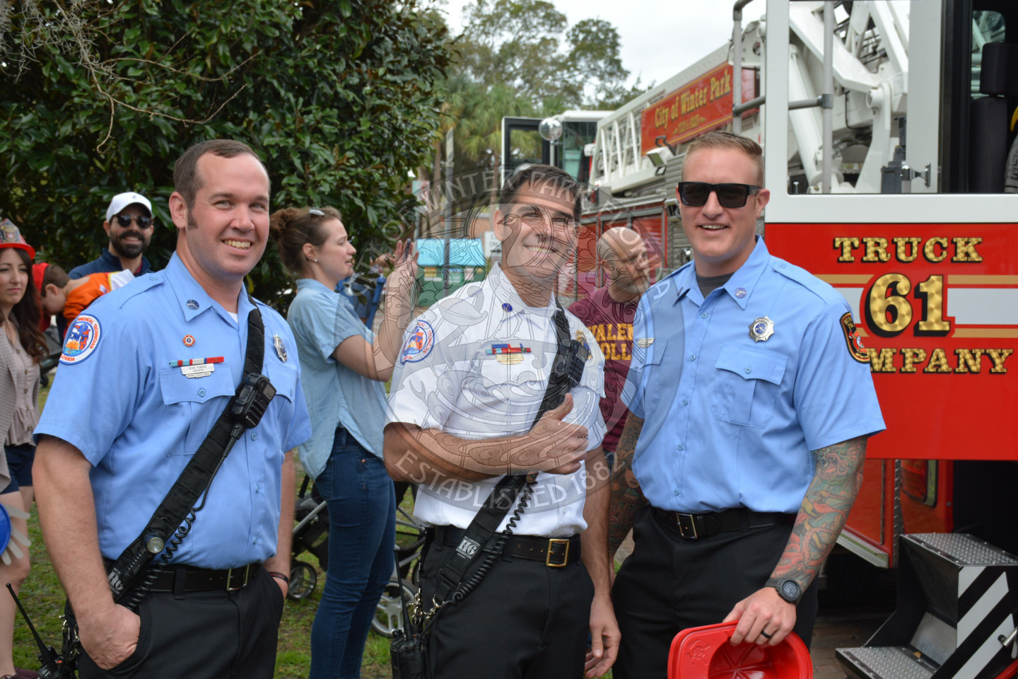 three firefighters in front of fire truck