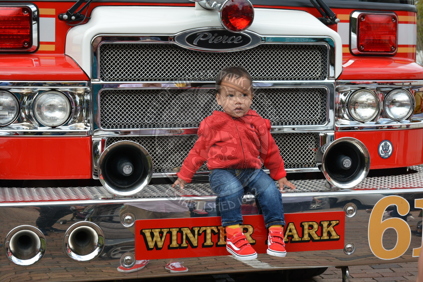 small boy sitting on bumper of fire truck