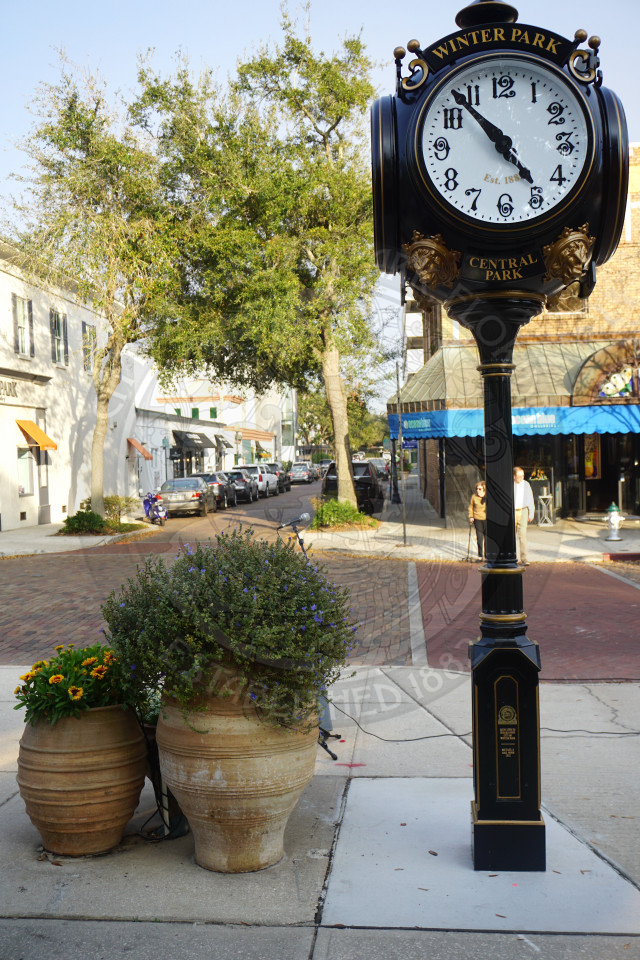 Historic clock in Central Park with views of park avenue behind it