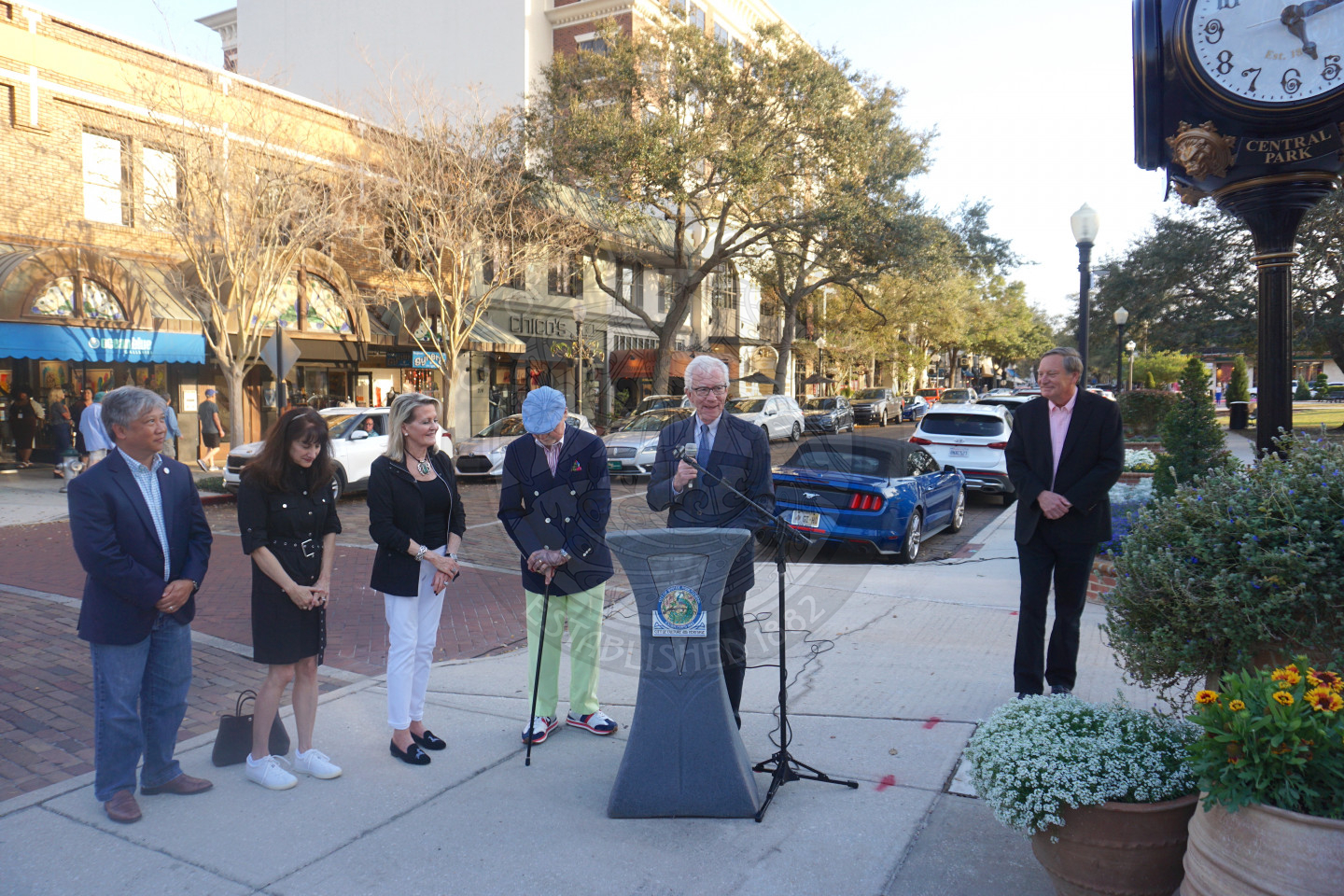 Mayor Phil Anderson talking behind podium with 4 people standing next to him.