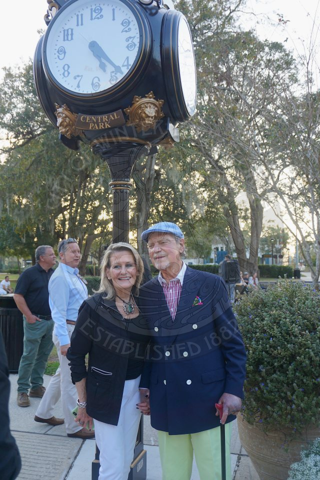 Michael and Gail Winn standing in front of the clock that is dedicated to them.
