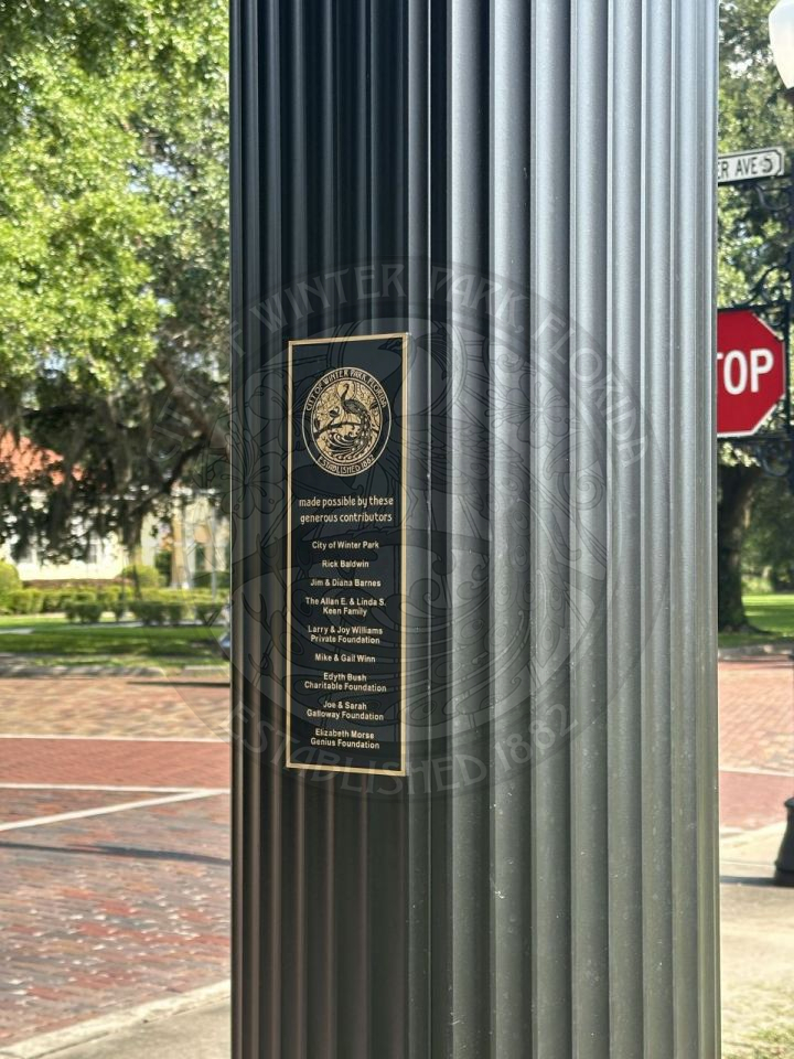 Dedication sign on a pole that says "made possible by these generous contributors" with a list of bunch of names.