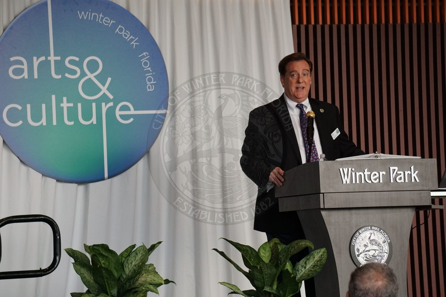 Man standing behind podium talking into microphone.