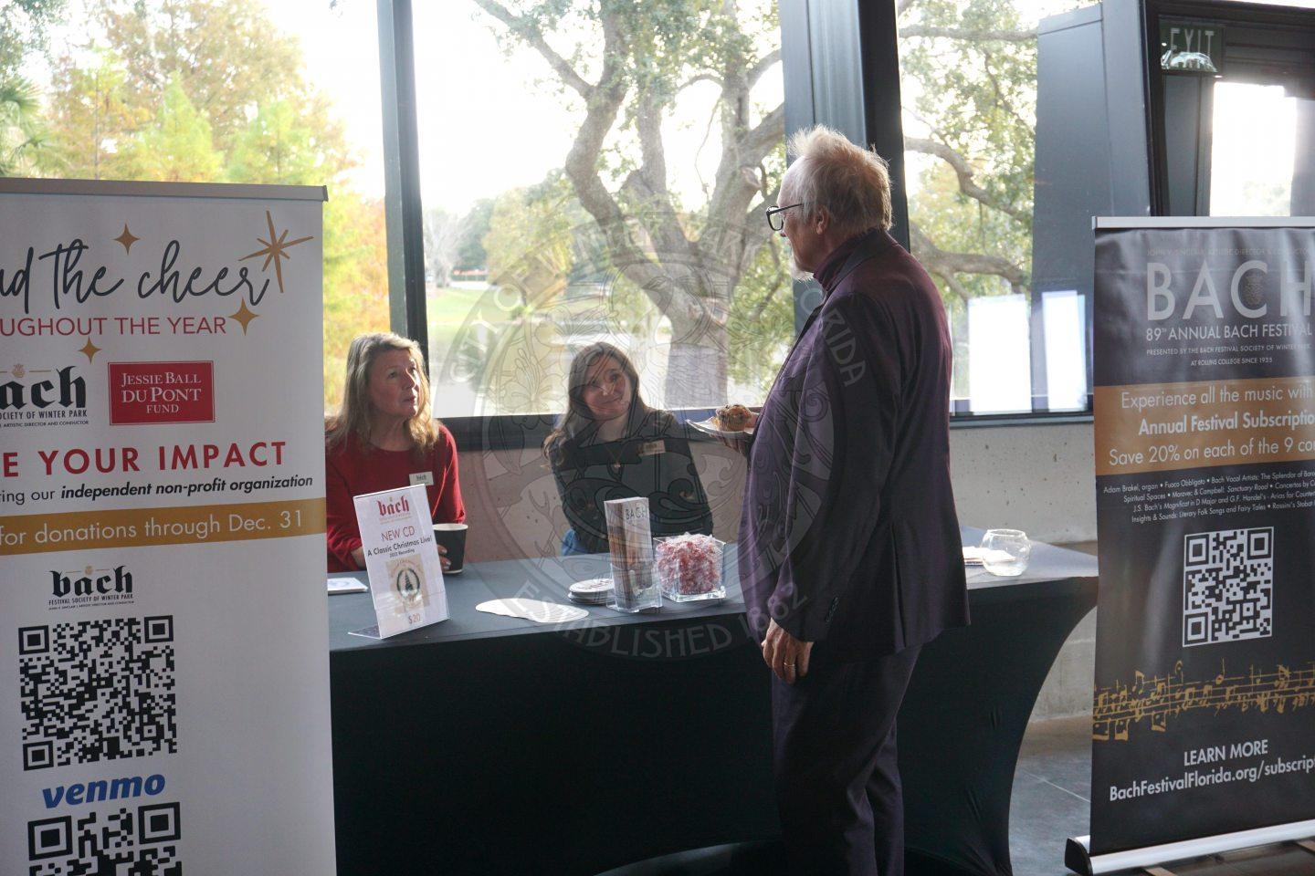 A man interacting with the Bach Festival table and getting information about the company.