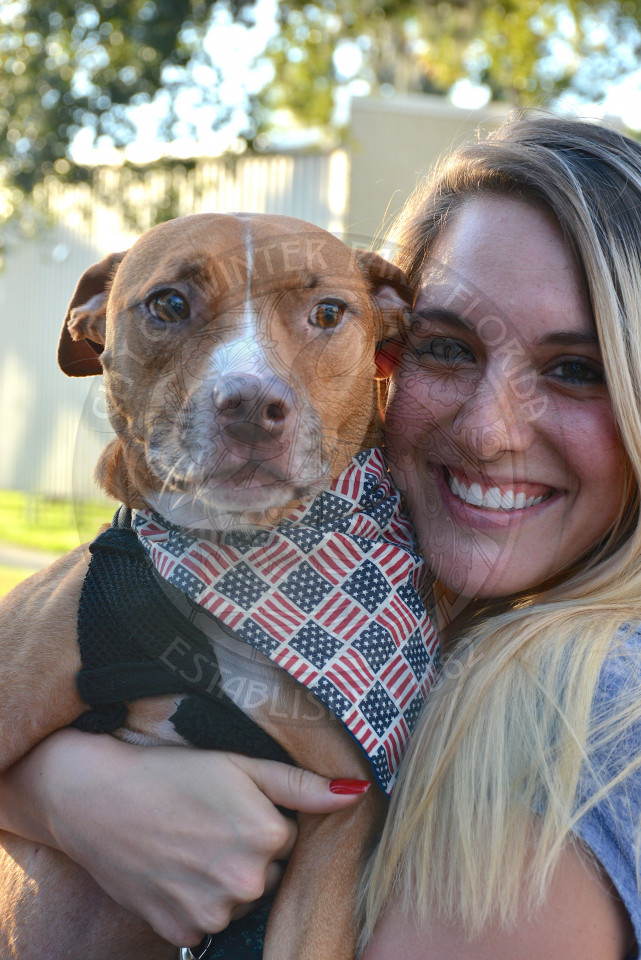 woman holding dog with American flag bandana