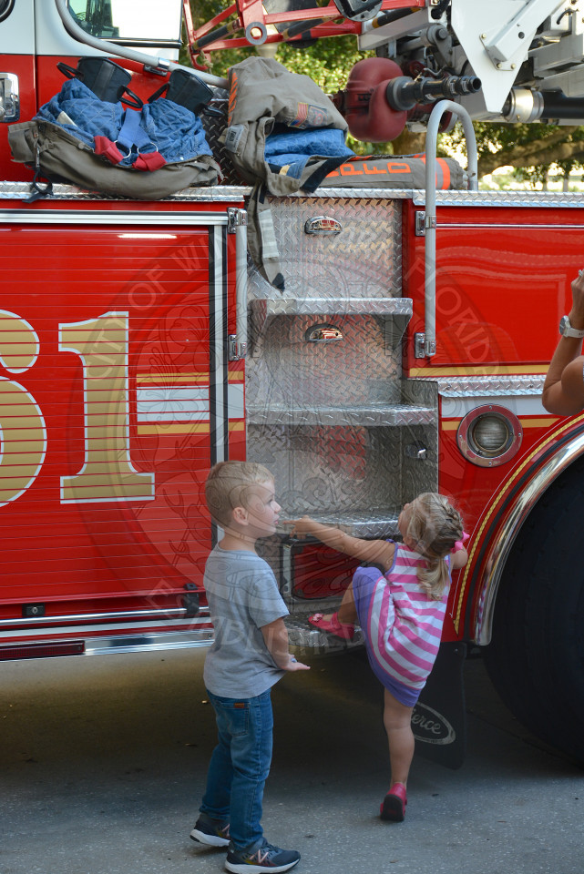 two children on side of display fire truck ready to climb aboard