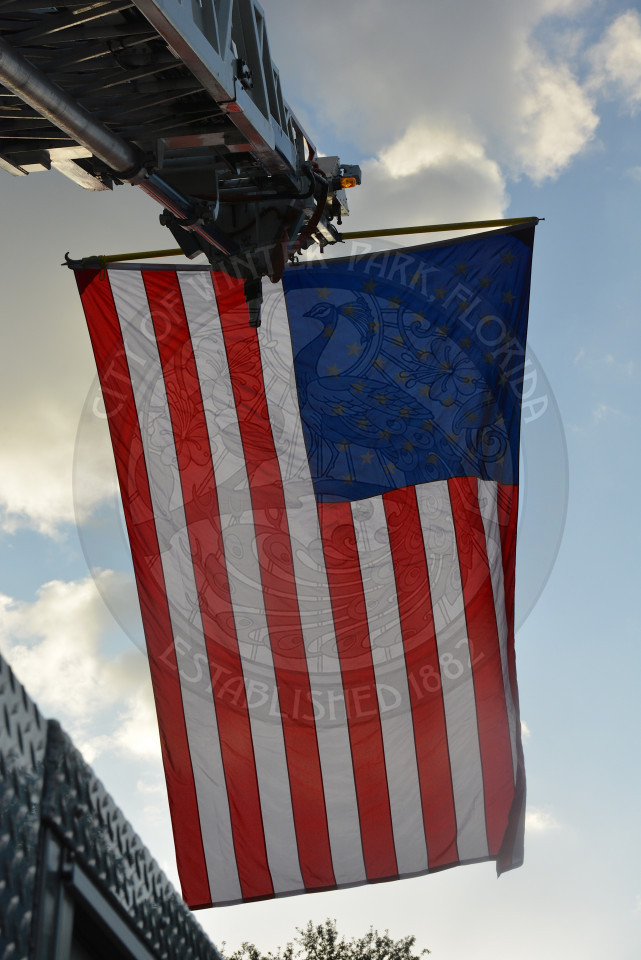 American flag with blue sky and white clouds in background
