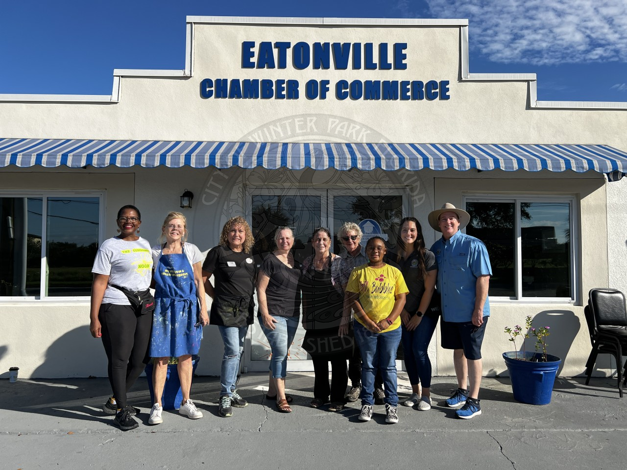 group of 9 people standing in front of the Eatonville Chamebr of Commerce building posing for a photo