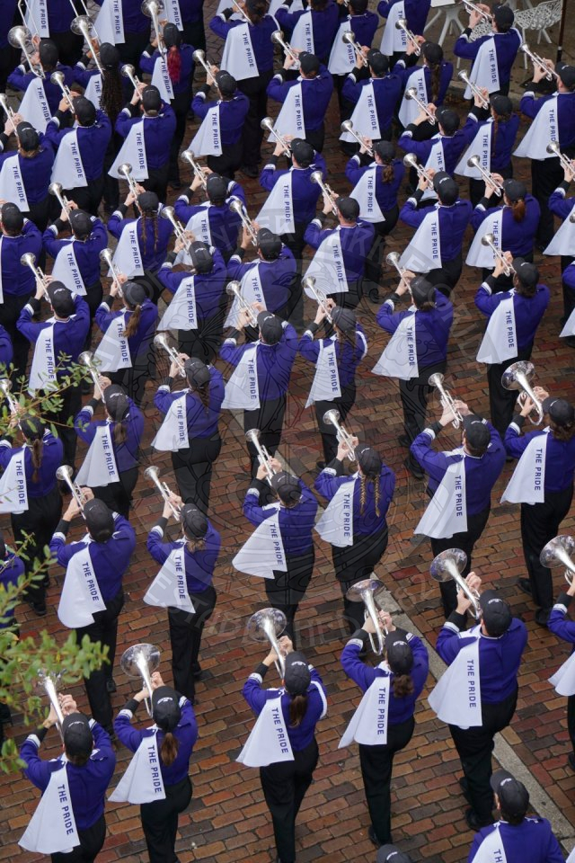 Ariel view of Kansas State trumpets marching down Park Avenue from behind.