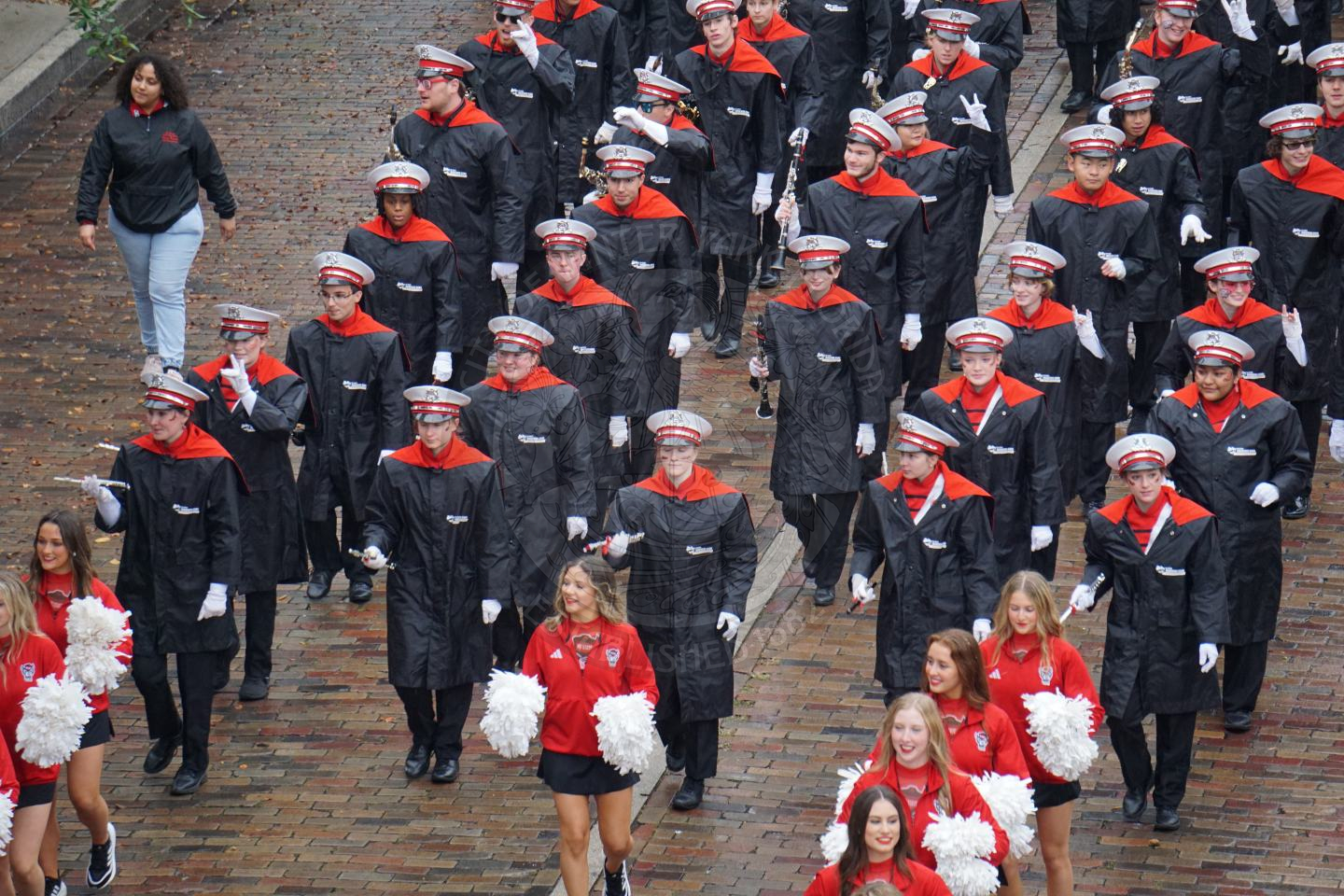 North Carolina State band members marching down Park Avenue with the light rain