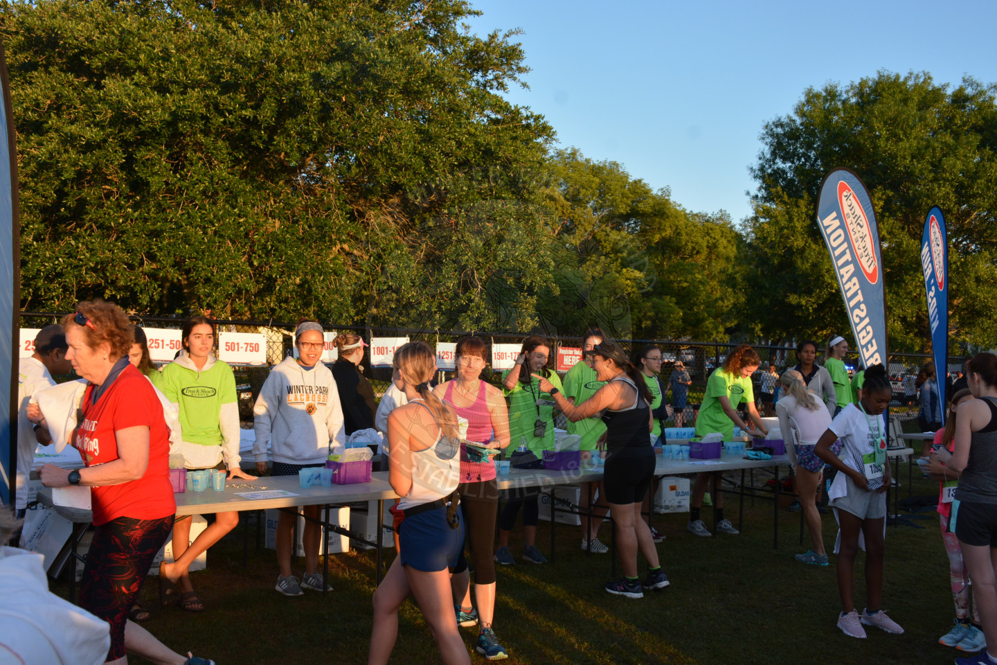 Runners at long tables picking up registration materials and giveaways