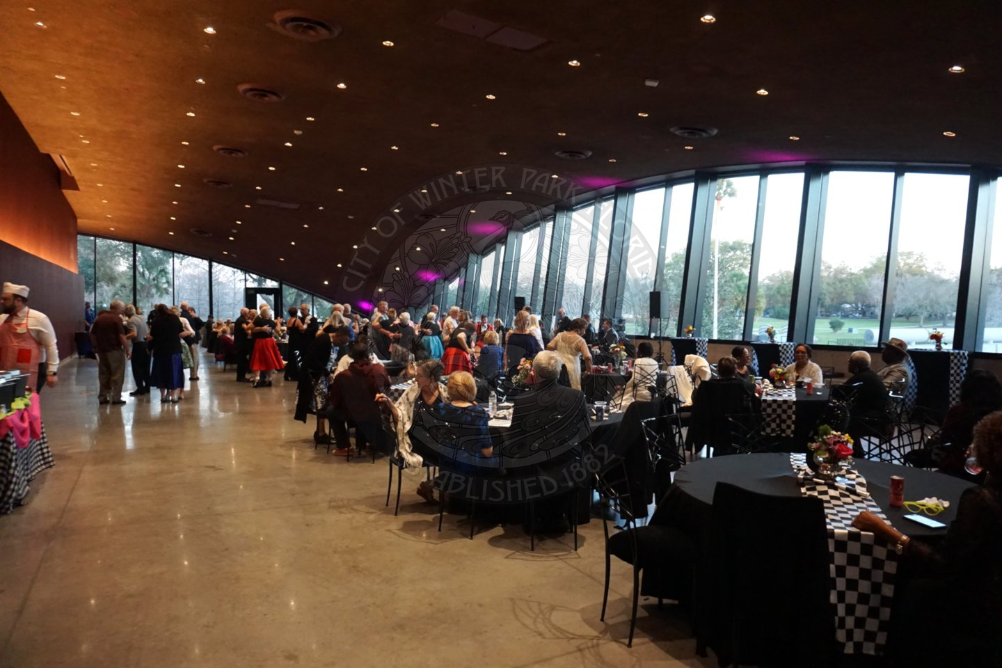 Overview of the ballroom with seniors sittind dwon at the tables enjoying their food.