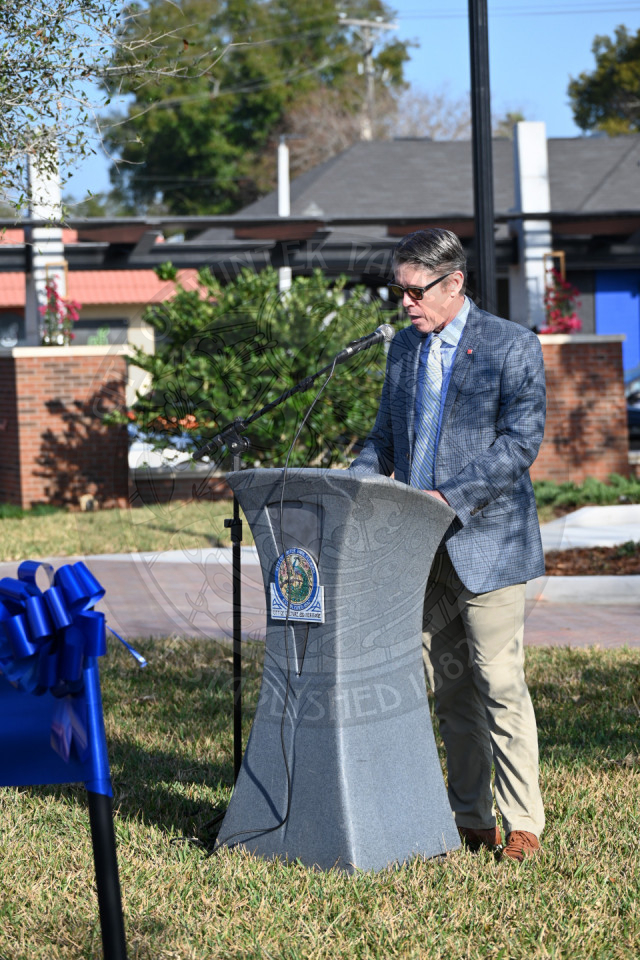A man standing behind a podium reading off a paper while talking into the microphone.