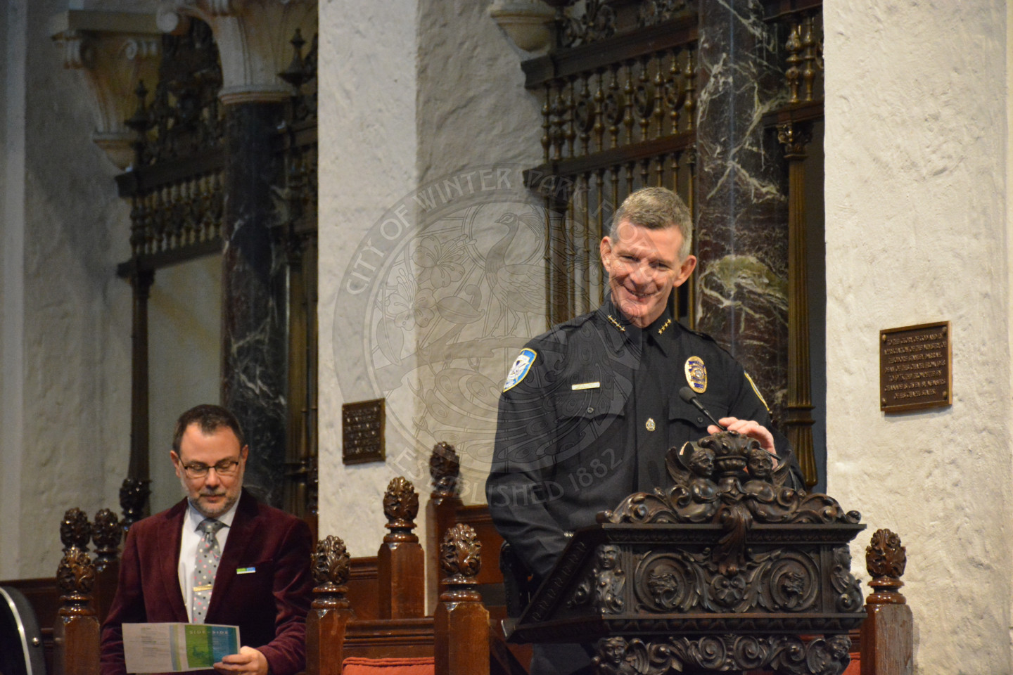 Police Chief Michael Deal smiling at the podium as he shares remarks