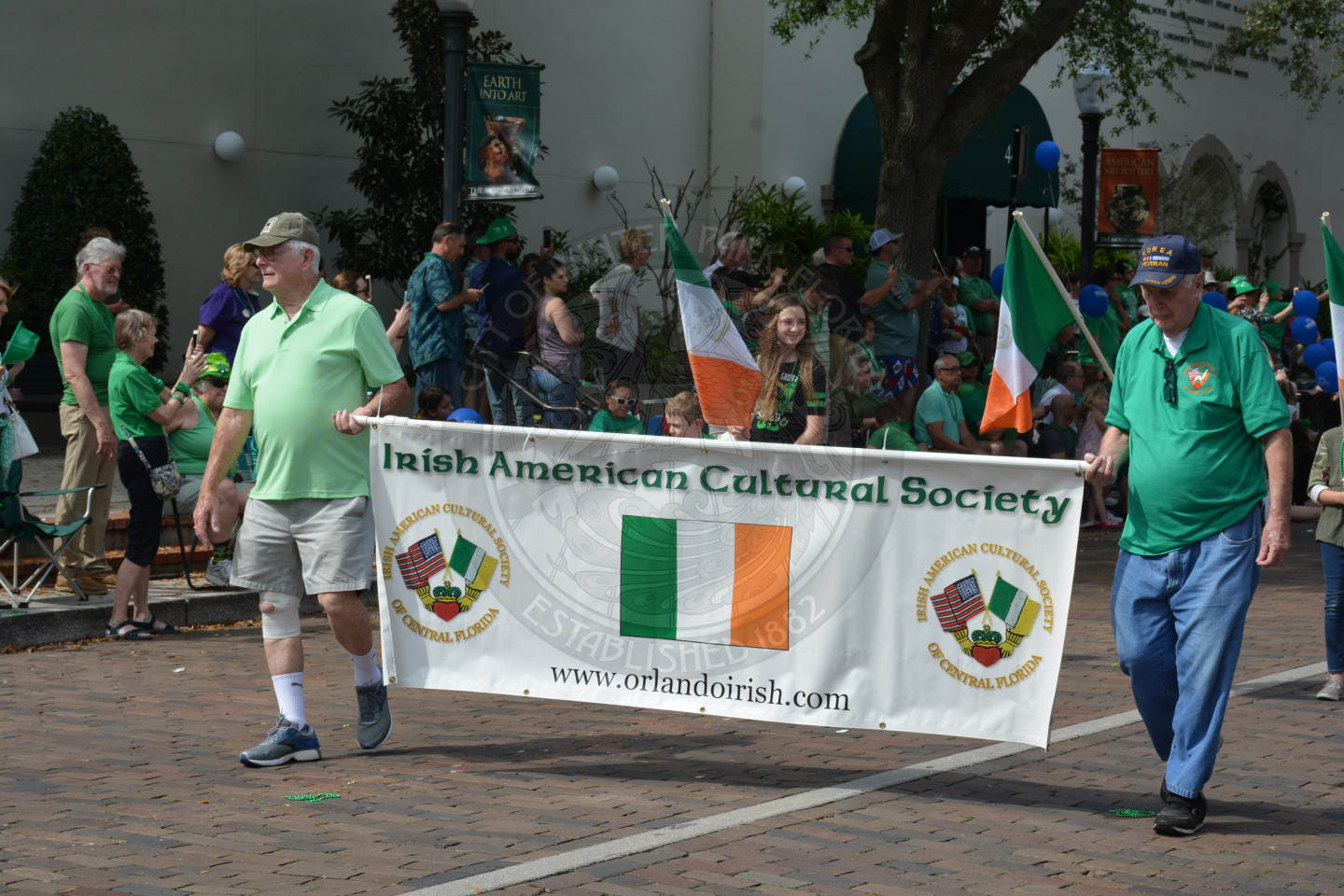 Two members of the Irish American Cultural Society hold a banner as they walk in the parade route.