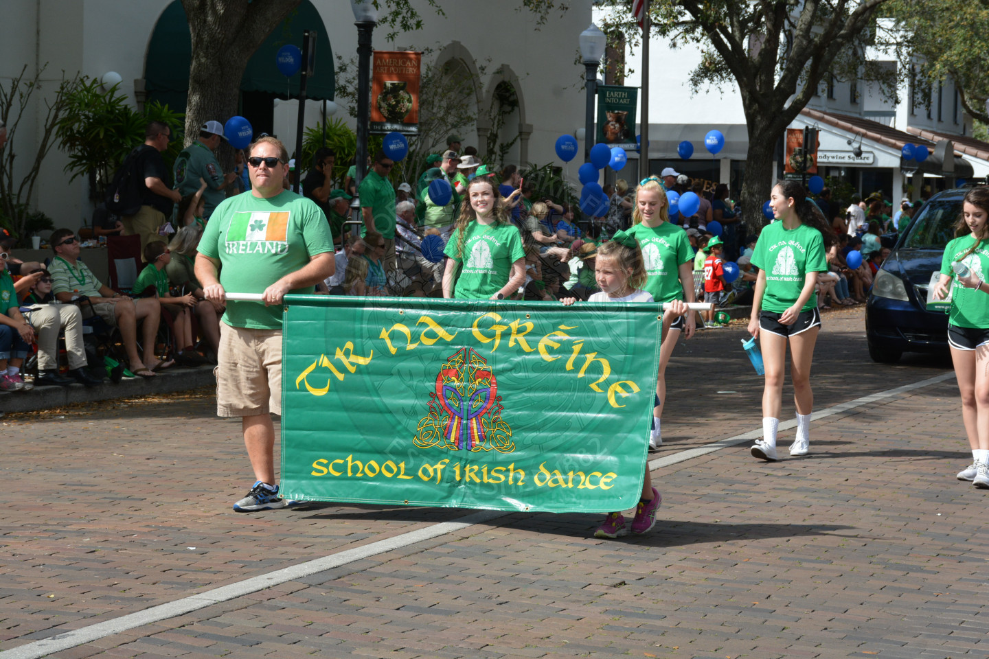 Man and young girl holding a banner for the school of Irish Dance