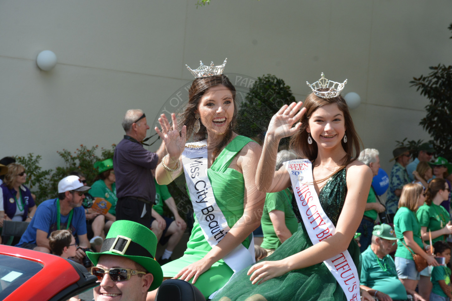 Miss City Beautiful and Miss Teen City Beautiful sitting in convertible vehicle waving to the crowd