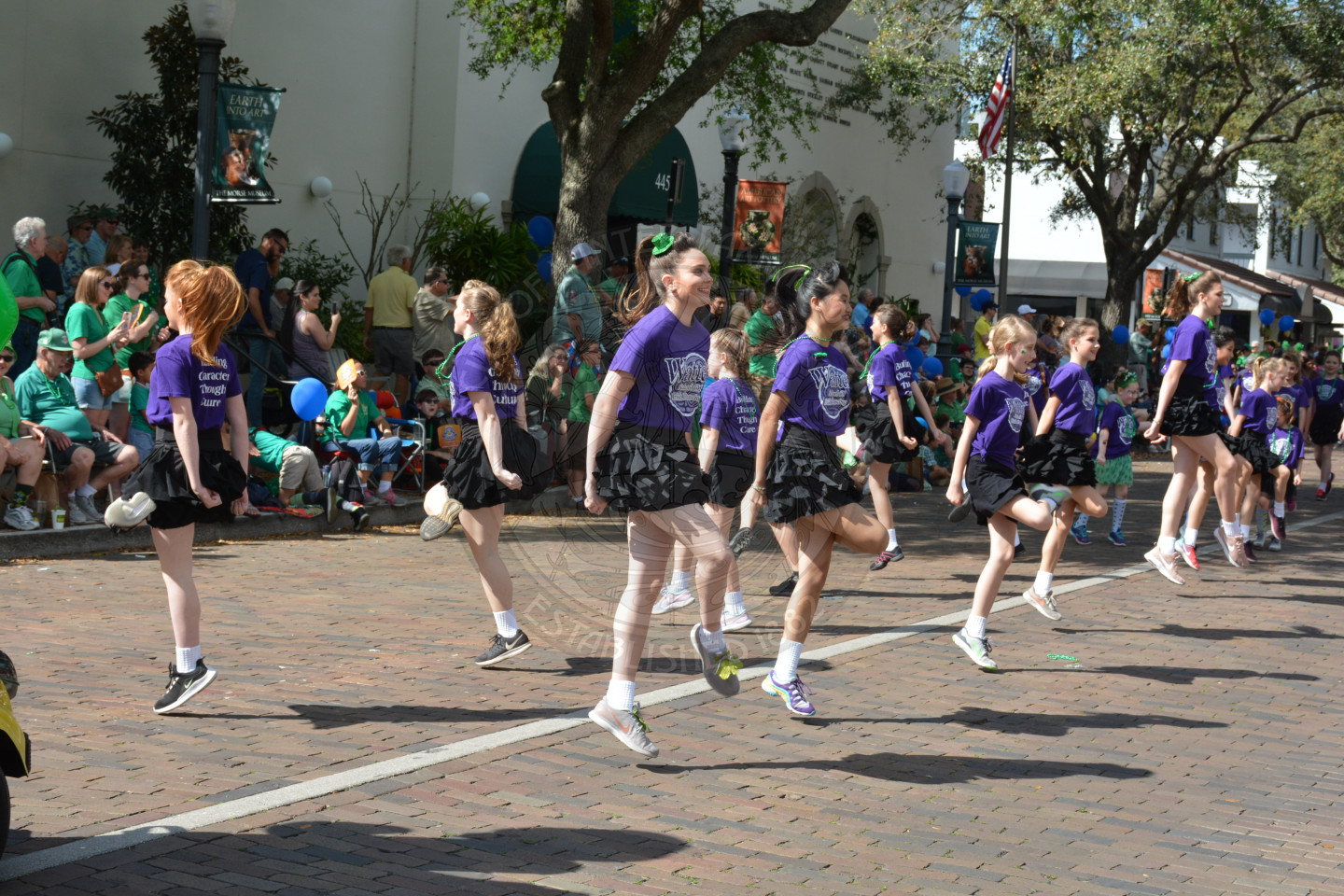 Two lines of dancers dancing down the parade route