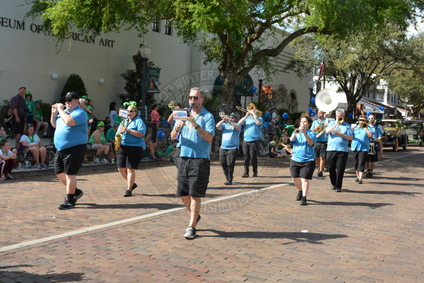 Band playing instruments as they walk down the parade route