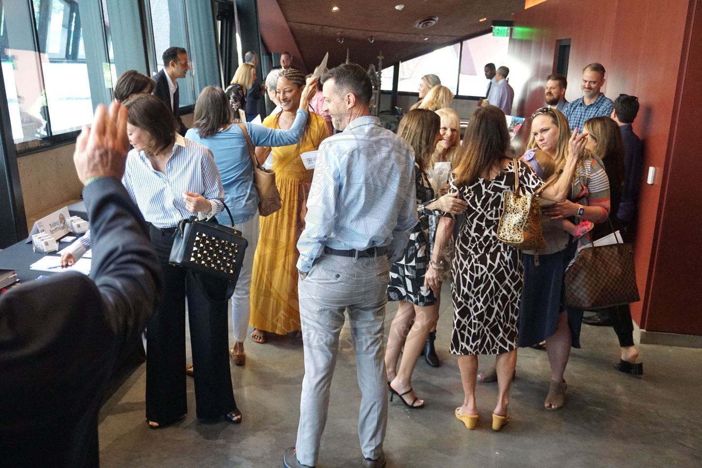 A picture of hallway with people mingling at department tables that are represented by city staff