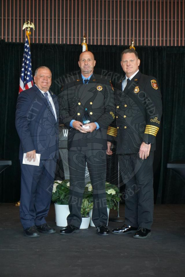 Winter Park Fire Employee of the year posing with the Fire Chief and city manager