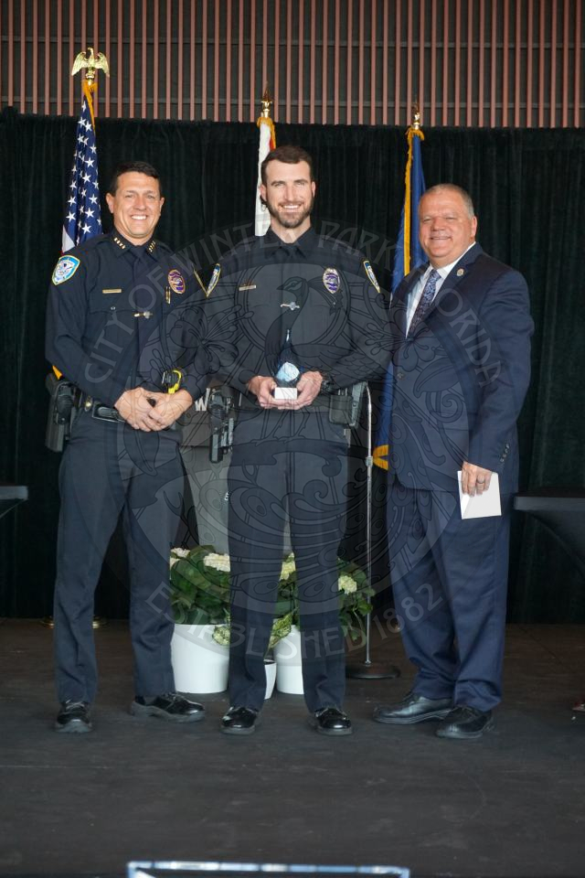 Winter Park Police Department Employee of the year posing with the police chief and city manager