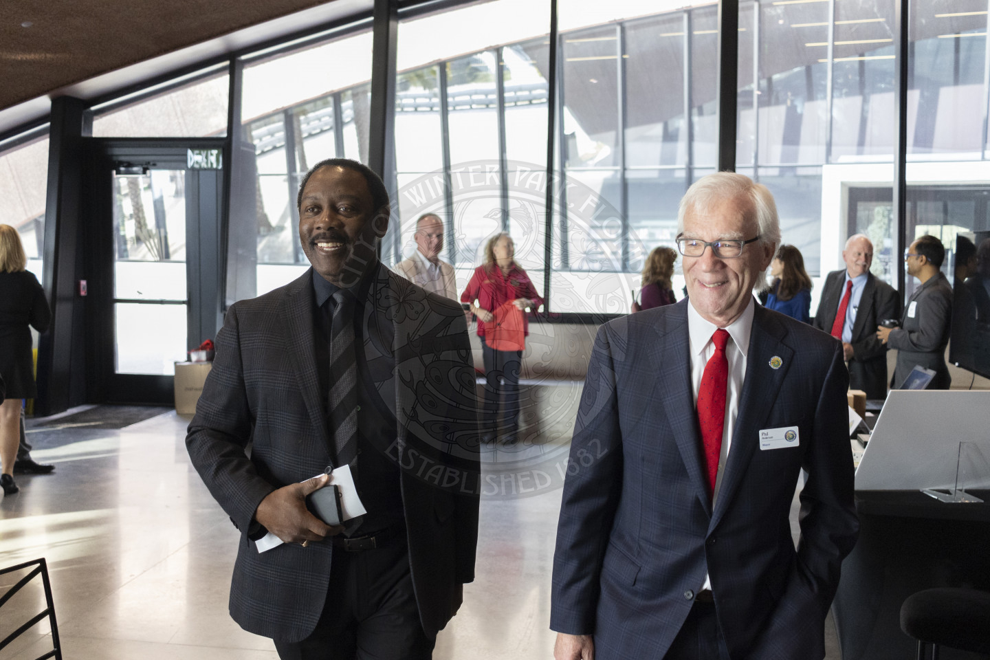Mayor Jerry Demings and Mayor Phil Anderson standing next to each other walking into the ballroom smiling.