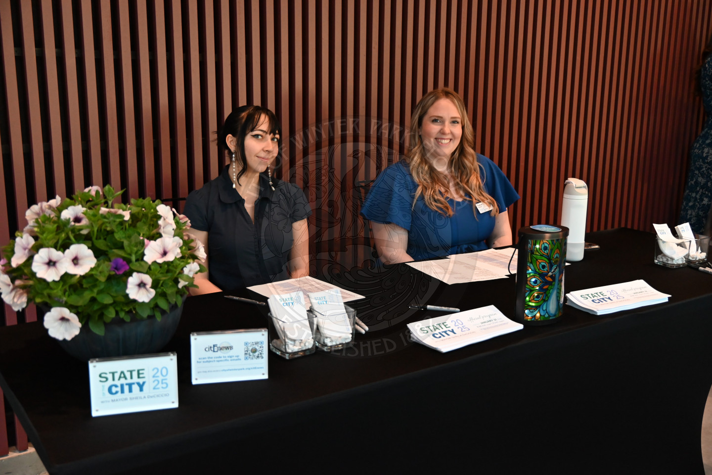 two females sitting behind the check in desk.