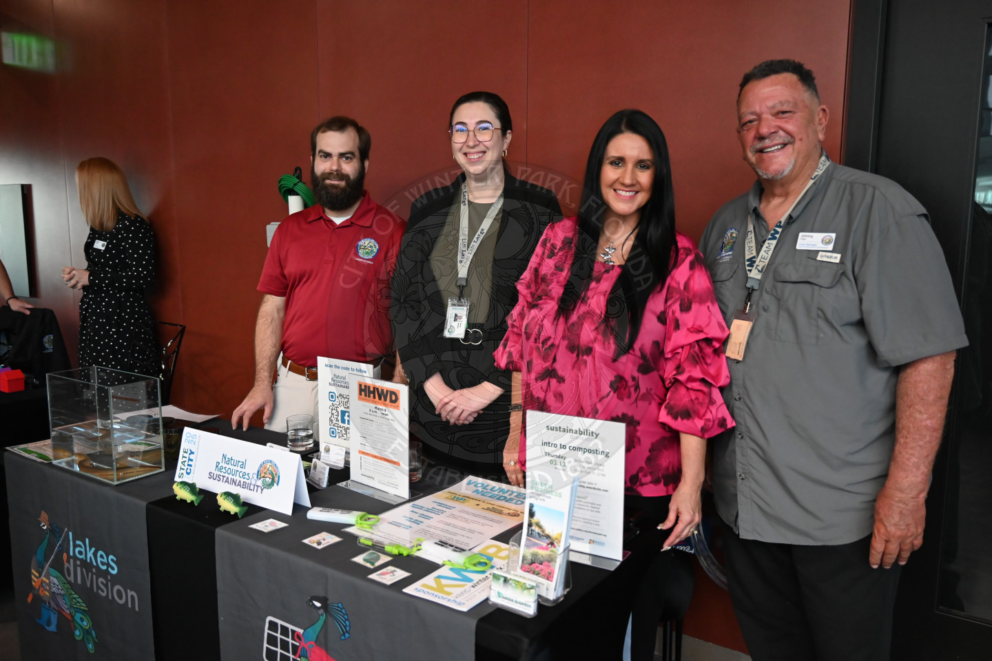 two males and two females standing behind a table with information about lakes and sustainability.