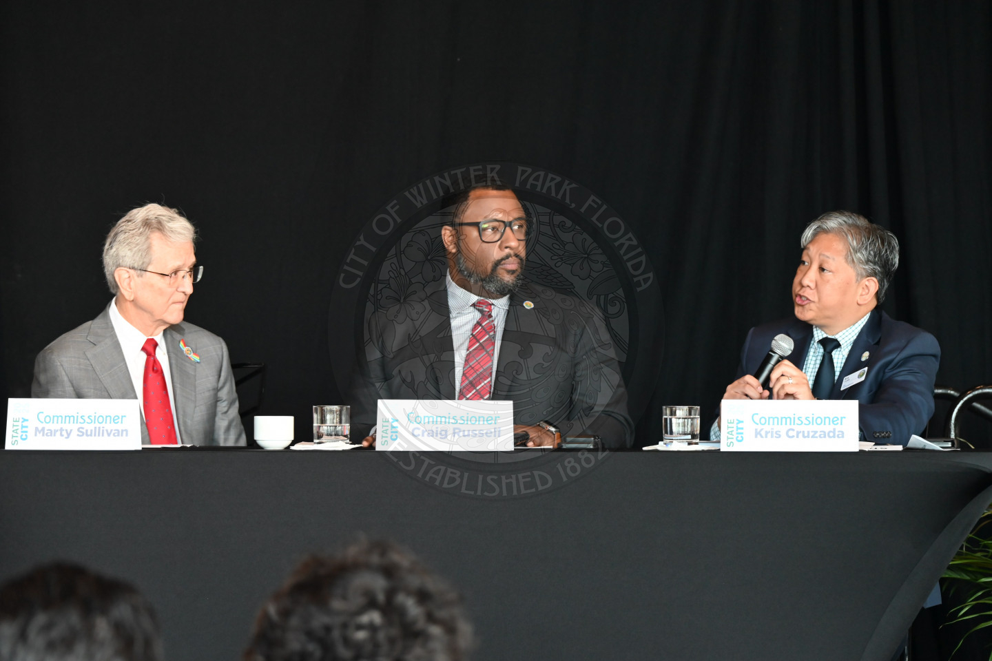 three male comissioners sitting at a table.