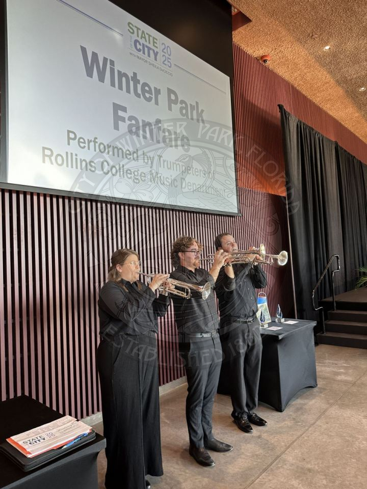 three trumpeteers playing their trumpets.