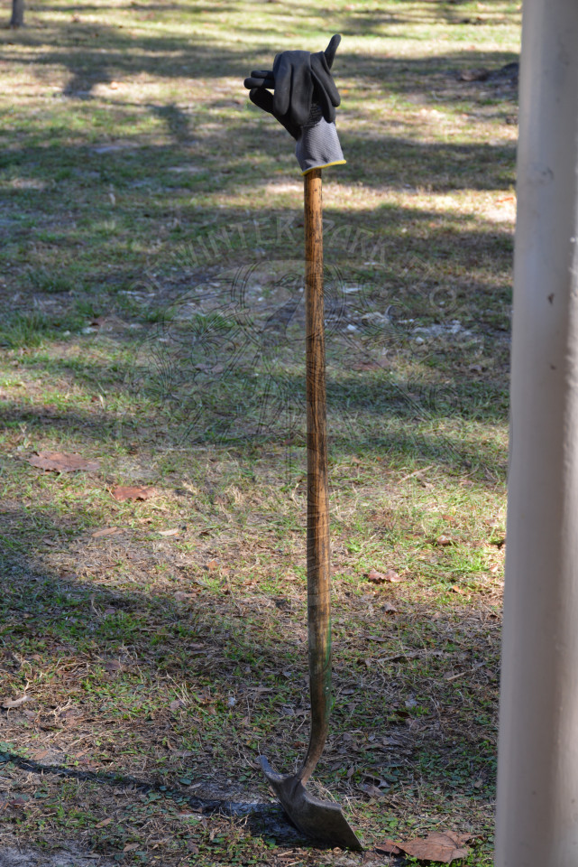 Shovel in the ground with a gardeners glove sitting on the top of the shovel