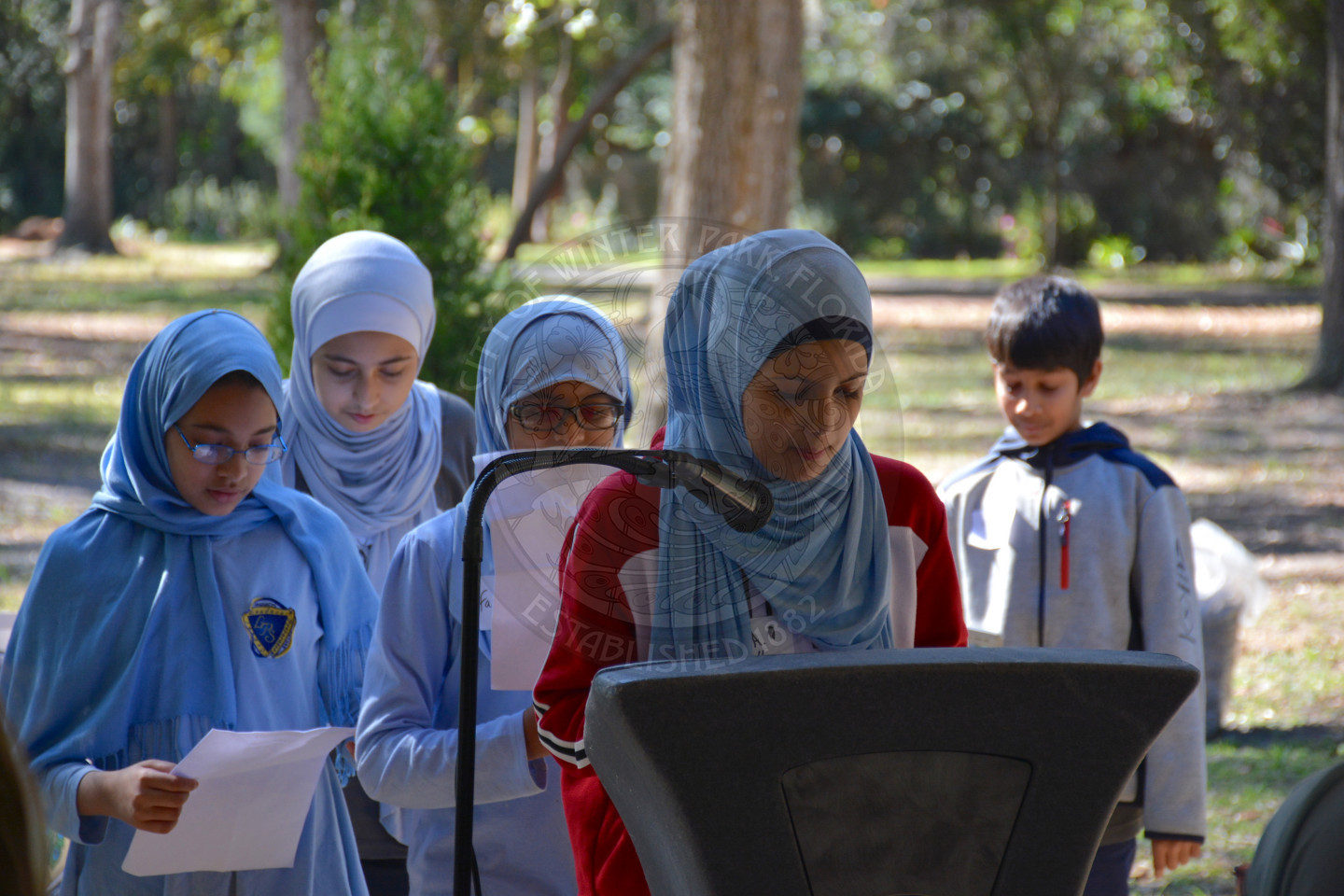 five students at the podium sharing remarks