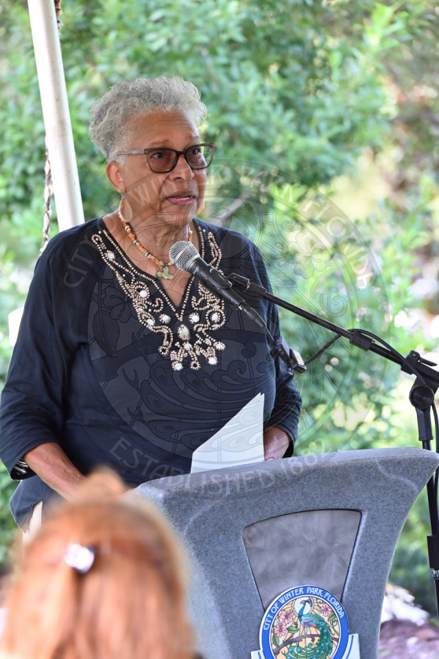 A lady standing behind a podium speaking into a microphone
