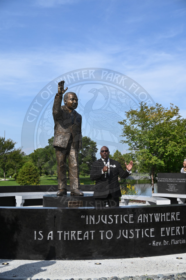 A man standing in front of Martin Luther King, Jr. statue