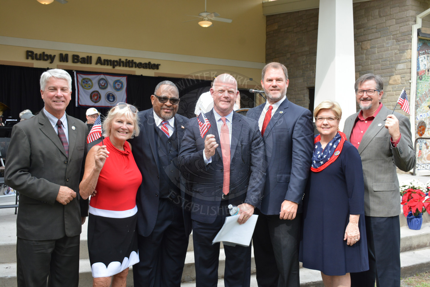 mayor and commissioners stand together and smile for a photo at the veterans day celebration