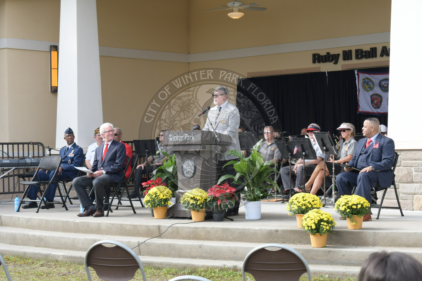 man standing on stage behing podium talking to audience