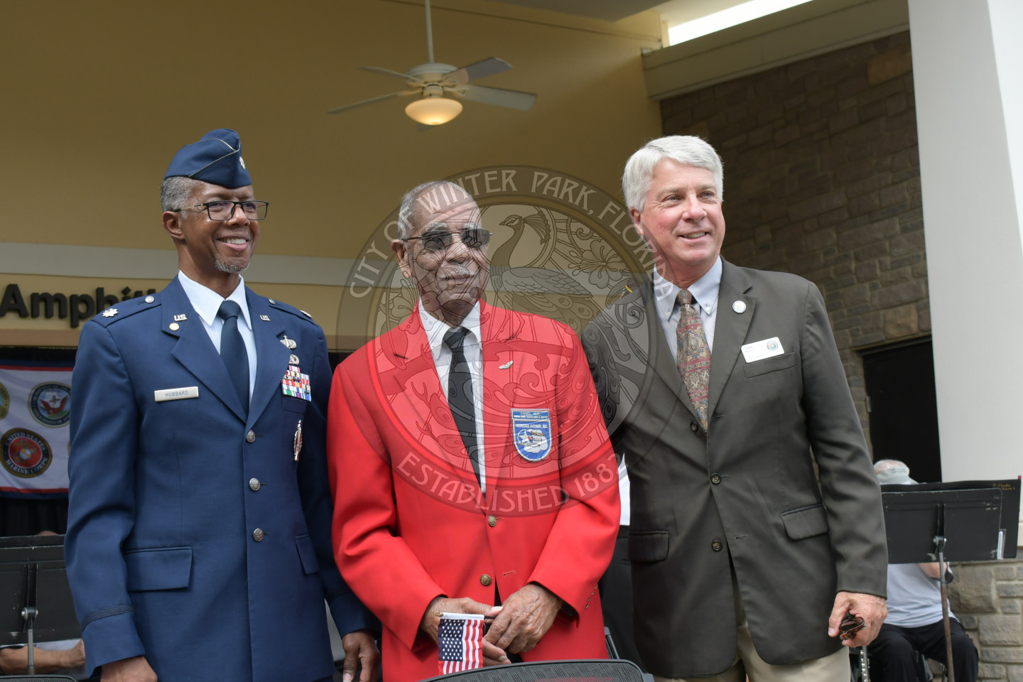 Commissioner Weaver and local veterans stand together and smile for a photo at the veterans day celebration