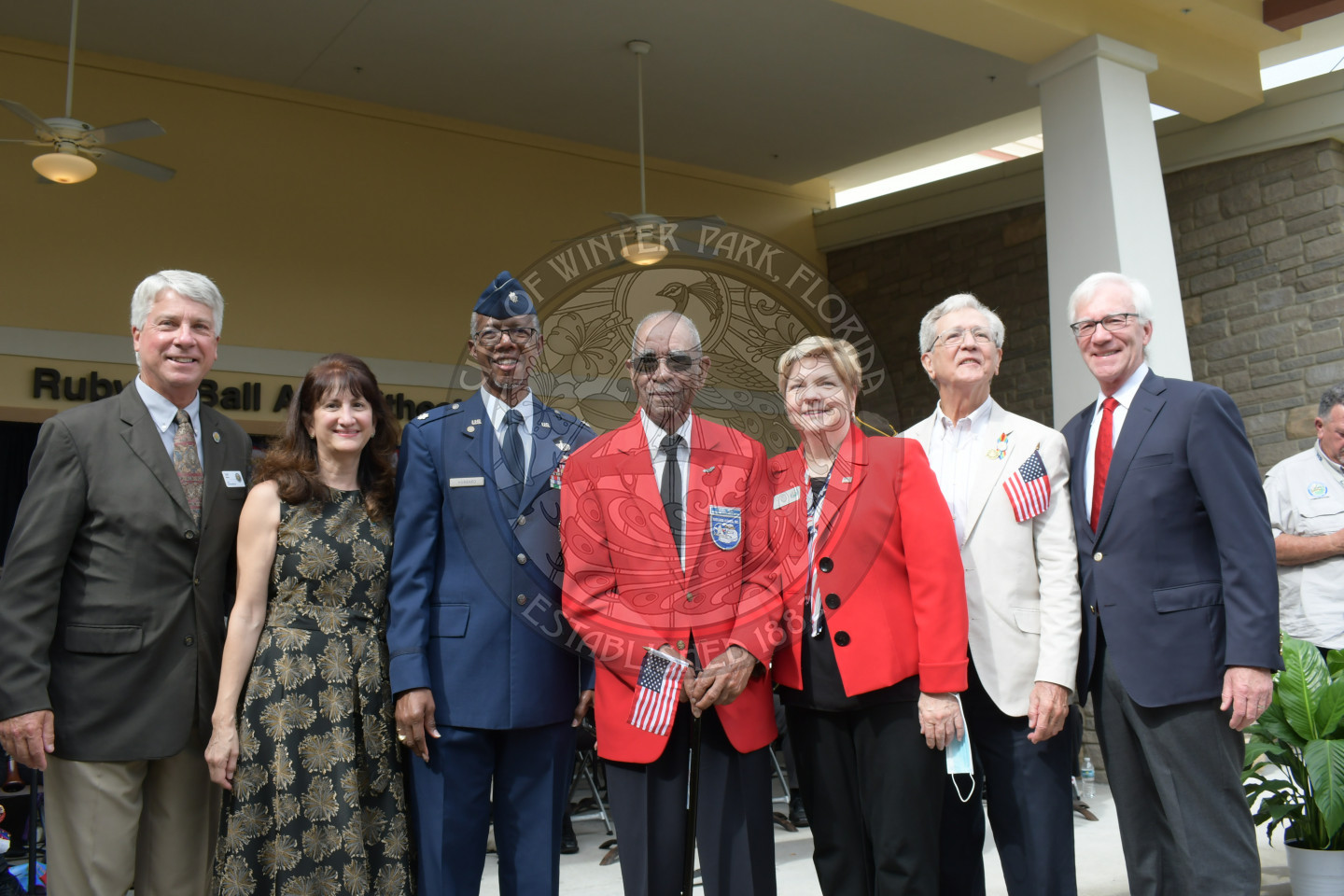 mayor, commissioners, and local veteran stand together and smile for a photo at the veterans day celebration