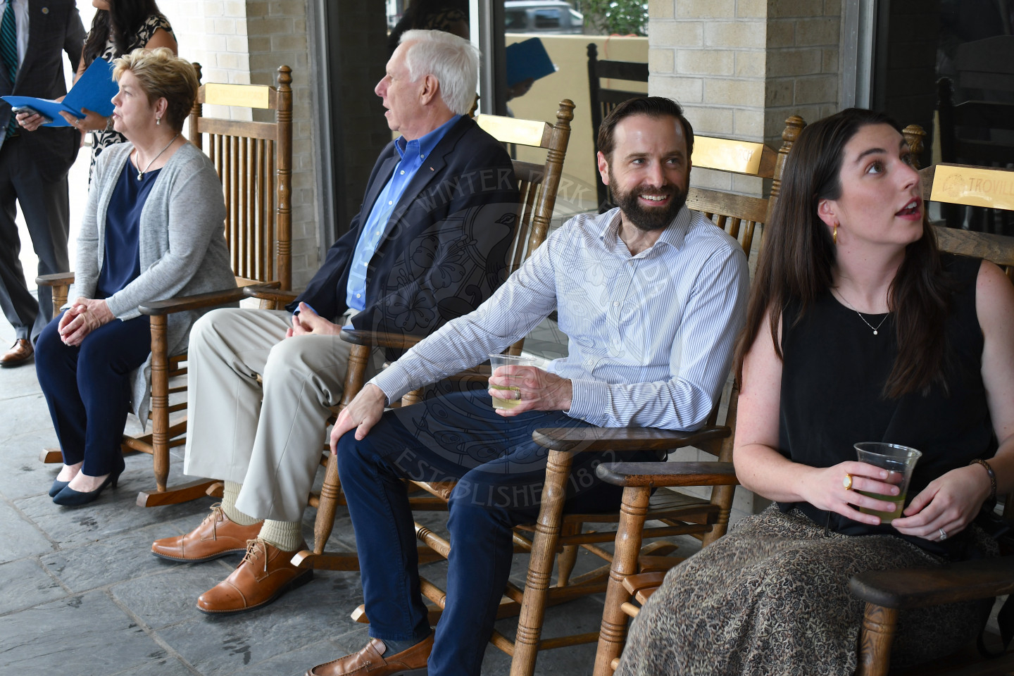 Group of men and women sitting in rocking chairs